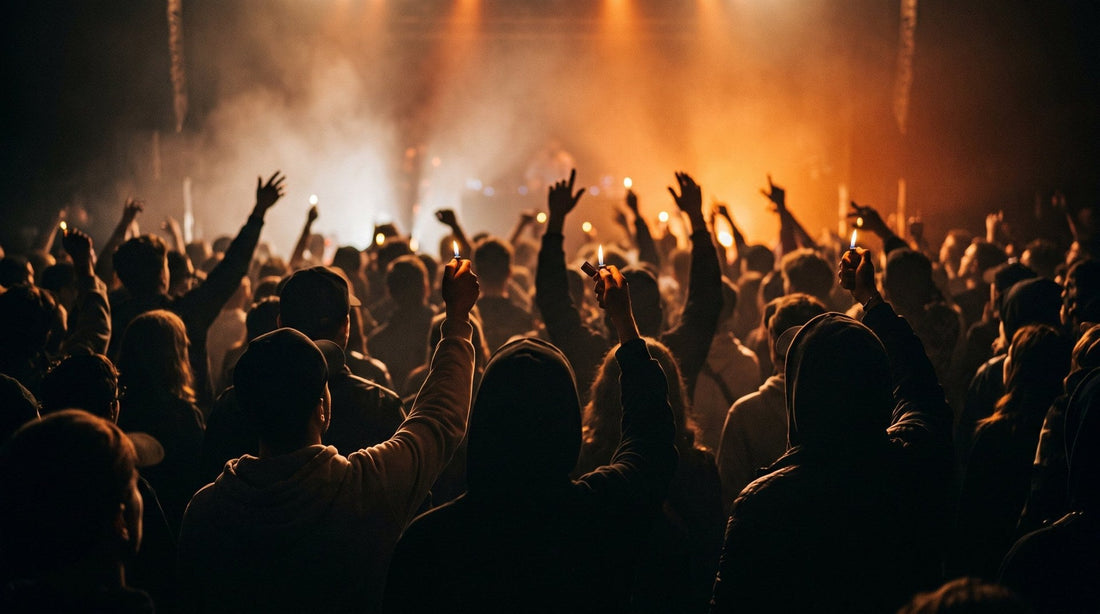 Concert crowd holding lit lighters in the air